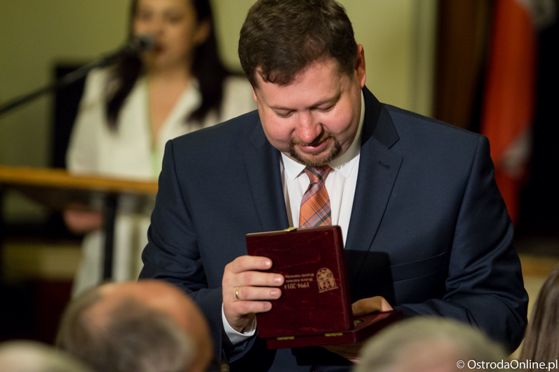 Sekretarz miasta Dariusz Struk odbiera pamiątkowy medal.